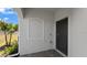 Home entrance featuring a dark front door, decorative window accent, and stone-paved entryway at 8069 Shore Lake Dr, Englewood, FL 34224