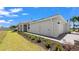 The side of the home features manicured landscaping, white exterior walls, and a gray paver driveway at 8089 Shore Lake Dr, Englewood, FL 34224