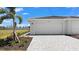 Close-up of a two-car garage with a white door, surrounded by fresh landscaping at 8089 Shore Lake Dr, Englewood, FL 34224