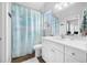 Bright bathroom featuring a white vanity, modern fixtures, and a beach-themed shower curtain at 876 Callista Cay Loop, Tarpon Springs, FL 34689