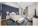 Cozy bedroom featuring a blue accent wall, tray ceiling, and bench with a plush area rug at 876 Callista Cay Loop, Tarpon Springs, FL 34689