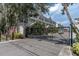 Exterior view of gated townhouse complex with red shutters and lush landscaping at 876 Callista Cay Loop, Tarpon Springs, FL 34689