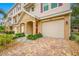 Charming townhome exterior with a one-car garage, brick paved driveway, and landscaped front yard at 876 Callista Cay Loop, Tarpon Springs, FL 34689