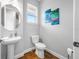Compact half bathroom with a modern pedestal sink, toilet, and tasteful decor for guests' convenience at 876 Callista Cay Loop, Tarpon Springs, FL 34689