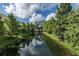 Scenic water view with green trees lining a quiet canal at 876 Callista Cay Loop, Tarpon Springs, FL 34689