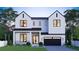 Striking modern home with a white brick facade, a covered porch, and a sleek black garage door at 902 W Fribley St, Tampa, FL 33603