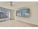 Bright bedroom with wood-look flooring, large window, and sliding glass door at 9111 Sterling Ln, Port Richey, FL 34668