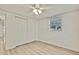 Bright bedroom features closet, sleek ceiling fan, and light, airy flooring with natural light at 9111 Sterling Ln, Port Richey, FL 34668