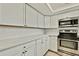 Modern kitchen showcasing white cabinetry, stainless steel appliances, and light-toned flooring at 9111 Sterling Ln, Port Richey, FL 34668