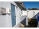 Side exterior entry with blue door, white siding, and updated light fixture at 1091 Mcfarland St, Dunedin, FL 34698