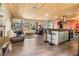 Open-concept living room and kitchen with a wood ceiling, gray tile floors, and a large window at 1091 Mcfarland St, Dunedin, FL 34698