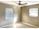 Light-filled bedroom with two windows, neutral walls, and a ceiling fan at 1101 King Arthur Ct, Valrico, FL 33594