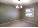 Cozy room with neutral paint, a chandelier, and a window overlooking a tree-lined street at 1101 King Arthur Ct, Valrico, FL 33594