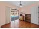 Bedroom with ceiling fan, hardwood floors, and a sliding glass door that exits to screened-in pool at 12333 Woodlands Cir, Dade City, FL 33525