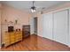 Bedroom with hardwood floors, ceiling fan, double closet, and doorway to the ensuite bathroom at 12333 Woodlands Cir, Dade City, FL 33525