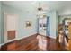 Bright bedroom showcasing hardwood floors, natural light from a large window, and a ceiling fan at 12333 Woodlands Cir, Dade City, FL 33525