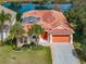 Beautiful home featuring lush landscaping, a charming red tile roof, and a spacious two-car garage at 12333 Woodlands Cir, Dade City, FL 33525