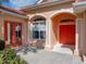 Home exterior featuring a double door entry, arched windows, and a landscaped front garden at 12333 Woodlands Cir, Dade City, FL 33525