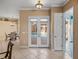 Hallway and dining area featuring tiled floors, double doors to the pool, and chandelier lighting at 12333 Woodlands Cir, Dade City, FL 33525