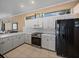 Bright kitchen featuring white cabinets, stainless steel oven, microwave, and a black refrigerator at 12333 Woodlands Cir, Dade City, FL 33525