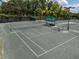 Well-maintained tennis courts with a shaded rest area for players create a recreational amenity at 12333 Woodlands Cir, Dade City, FL 33525