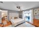 Bright bedroom with hard wood floors, ceiling fan, and sliding doors to the lanai with sunlight streaming in at 1242 Holly Cir, Oldsmar, FL 34677