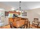 Bright dining area with hardwood floors, a wooden table, and a view of the kitchen with a breakfast bar at 1242 Holly Cir, Oldsmar, FL 34677