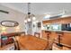 Dining area with a wooden table, chairs, and an overhead light fixture near the bar and kitchen at 1242 Holly Cir, Oldsmar, FL 34677