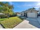 A one-story home with tan siding and a one-car garage, complemented by a well-maintained green lawn at 1242 Holly Cir, Oldsmar, FL 34677