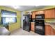 Kitchen featuring wood cabinets, black appliances, and tiled floors, illuminated by natural light at 1242 Holly Cir, Oldsmar, FL 34677