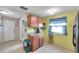 Compact kitchen with wood cabinets, tiled floor, and bright yellow walls, showcasing a functional layout at 1242 Holly Cir, Oldsmar, FL 34677