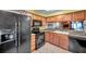 Kitchen featuring wood cabinetry, granite countertops, and black appliances, offering a warm and inviting cooking space at 1242 Holly Cir, Oldsmar, FL 34677