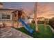 Backyard with a slide, a wooden playhouse, and artificial grass at 1336 51St Ne Ave, St Petersburg, FL 33703