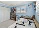 Bright bedroom with blue walls, window shutters, closet, bookshelve, and decorated with athletic awards at 1336 51St Ne Ave, St Petersburg, FL 33703