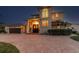 The home's facade is beautifully illuminated at night with a brick driveway at 1336 51St Ne Ave, St Petersburg, FL 33703