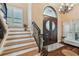 Elegant foyer showcasing hardwood stairs, statement lighting, and a decorative front door at 1336 51St Ne Ave, St Petersburg, FL 33703