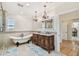 Bright and spacious main bathroom featuring a soaking tub, dual vanities, and decorative chandeliers at 1336 51St Ne Ave, St Petersburg, FL 33703