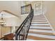 Elegant staircase with wood steps, an ornate black railing, and views of the living area at 1336 51St Ne Ave, St Petersburg, FL 33703