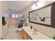 Well-lit bathroom featuring a large mirror, white tiled floors, and a bathtub with shower at 1401 Ventana Dr, Sun City Center, FL 33573