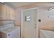 Cozy laundry room with modern washing machine and overhead cabinet storage space at 1401 Ventana Dr, Sun City Center, FL 33573