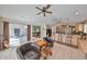 Open concept living room with tiled floors and sliding glass doors to lanai, adjacent to a breakfast bar and kitchen at 1401 Ventana Dr, Sun City Center, FL 33573