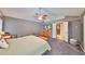 Well-lit main bedroom with gray walls, a ceiling fan, and doors to the main bathroom at 1401 Ventana Dr, Sun City Center, FL 33573