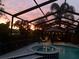 Beautiful evening view of the screened-in pool area with integrated hot tub and seating area at 1401 Ventana Dr, Sun City Center, FL 33573