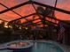 Stunning sunset view from screened-in pool area featuring a hot tub and covered seating, perfect for evening relaxation at 1401 Ventana Dr, Sun City Center, FL 33573