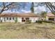 Backyard showing patio, sliding glass door, and mature trees at 14810 Feather Cove Ln, Clearwater, FL 33762