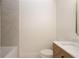 Bathroom featuring a modern tub, marble tiling, single vanity with a quartz countertop, toilet, and brushed gold fixtures at 14810 Feather Cove Ln, Clearwater, FL 33762