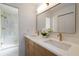 Bathroom with dual sinks, marble countertop, framed mirror, and a glass enclosed shower with modern fixtures at 14810 Feather Cove Ln, Clearwater, FL 33762