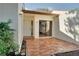 An outdoor patio featuring brick flooring, a white front door, and a sliding glass door to the main house at 14810 Feather Cove Ln, Clearwater, FL 33762