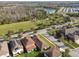 Aerial view of a residential area with a lake, a park, and modern houses with well-maintained lawns at 17596 Terrazzo Way, Land O Lakes, FL 34638