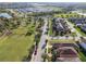 An aerial view showcases a neighborhood with houses, a park, and trees lining the street at 17596 Terrazzo Way, Land O Lakes, FL 34638